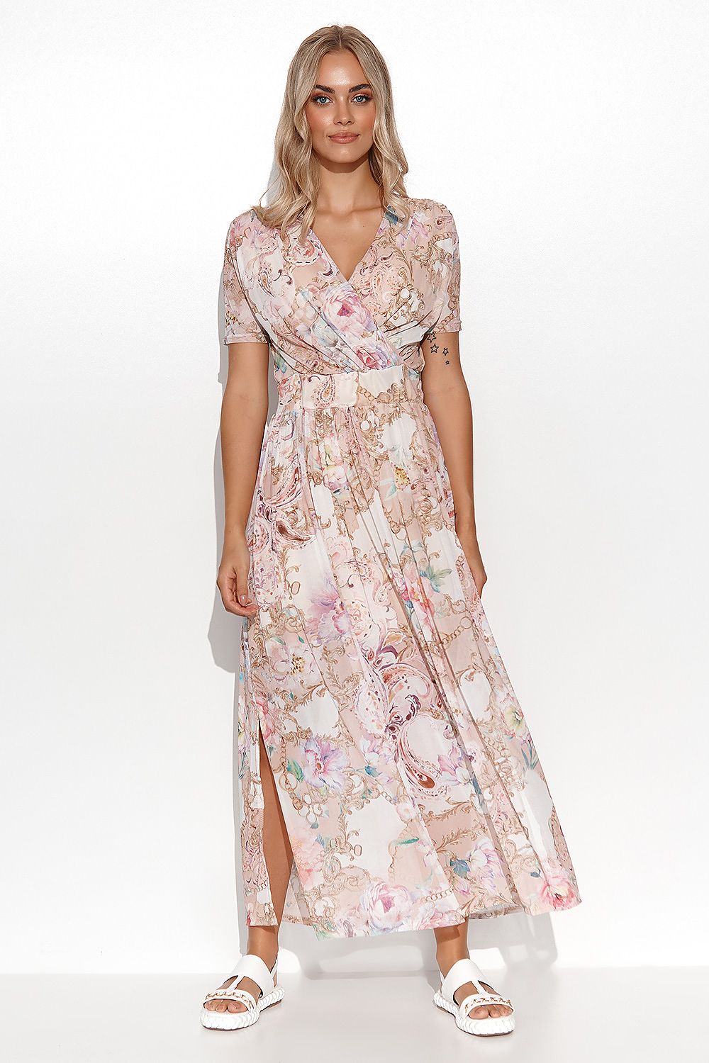 Elegantly styled Makadamia mini dress featuring a sensual neckline and captivating floral and abstract motifs. The model showcases the intricate design, perfect for summer occasions.