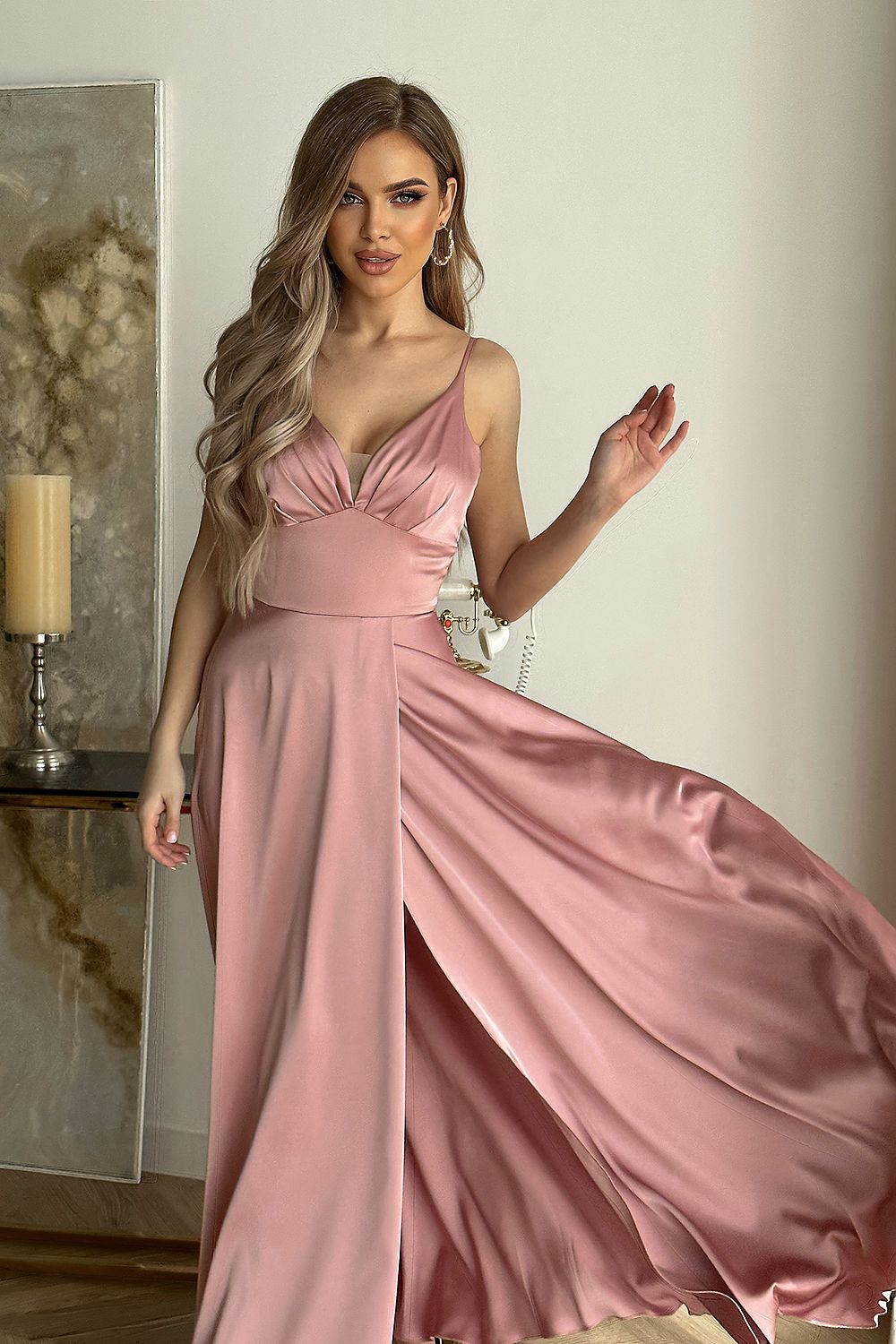 Bicotone satin evening dress in soft pink, highlighting the delicate cut-out design and flowing skirt, model twirling to display the elegant silhouette.