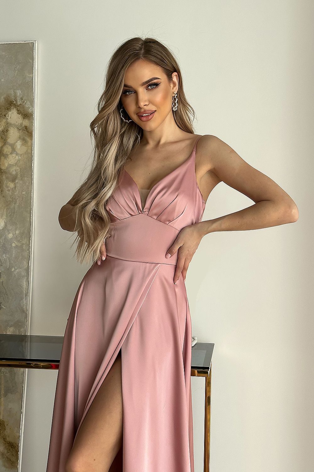 Cut-out satin evening dress by Bicotone in soft pink, model presenting the chic features and thigh-high slit, exuding luxury and sophistication.