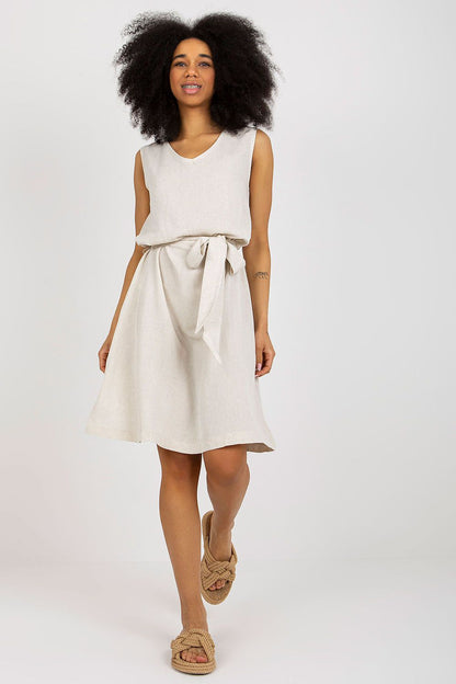 Chic summer dress by Rue Paris showcasing a flattering design with a v-neckline, waist tie, and flowy silhouette, styled with casual footwear for effortless elegance.