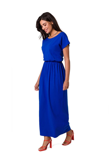 Elegant BeWear cotton maxi dress in vibrant blue featuring an asymmetrical neckline and an elastic waistband, styled with chic red heels.