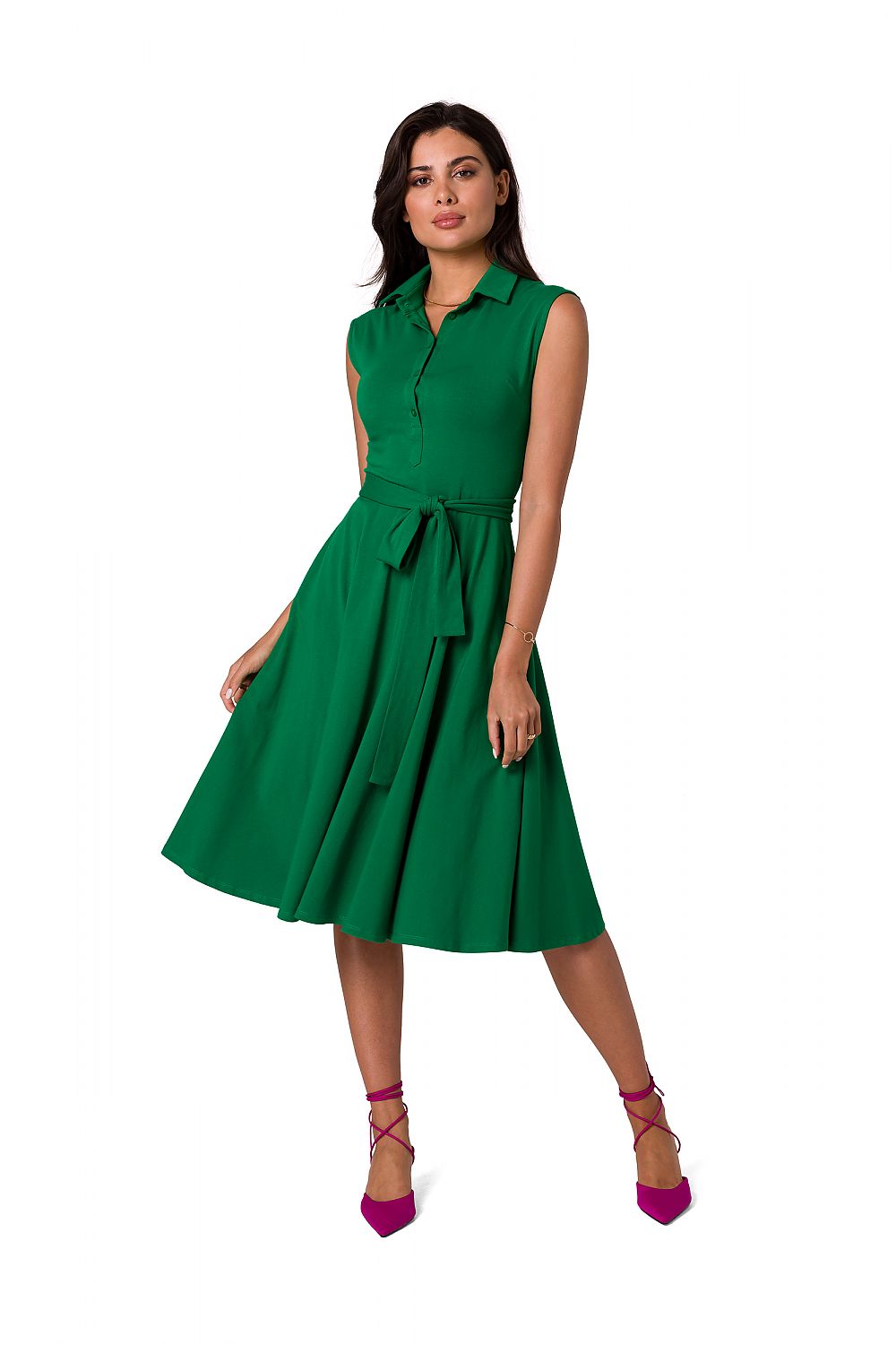 Elegant sleeveless daydress by BeWear, featuring a sophisticated collar and a flared bottom, perfect for warm days. The dress is styled in a rich green colour, accentuated with a fabric tie belt, complemented by chic pink heels for a refined look.