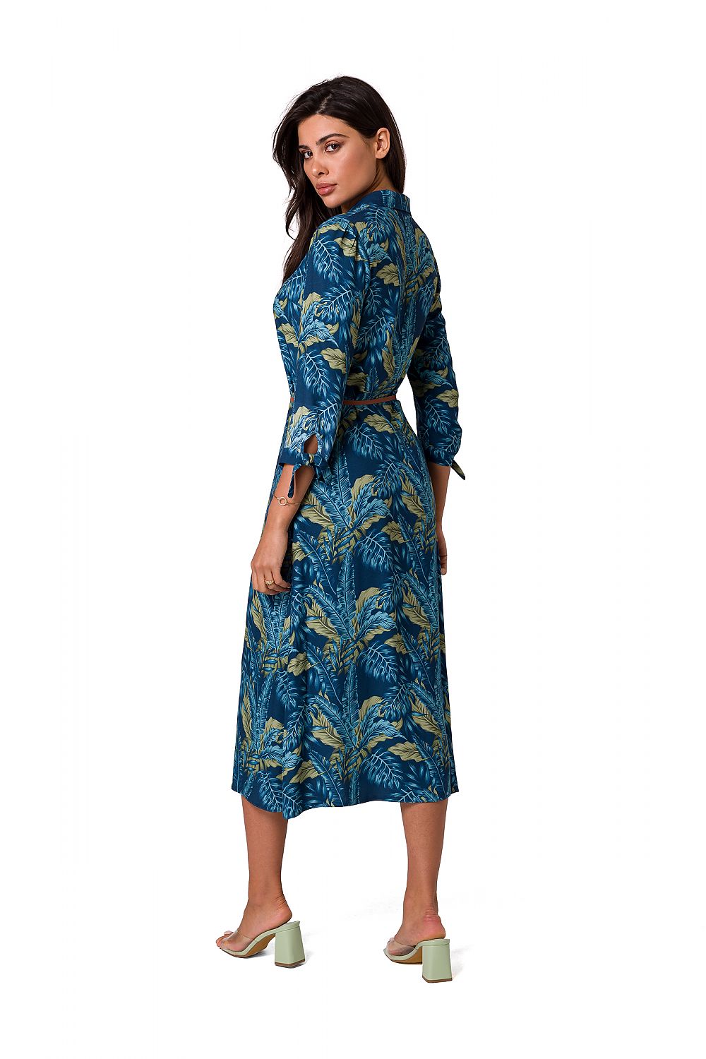 Back view of a luxury A-line daydress in blue with a tropical leaf pattern, by BeWear. The dress features a flattering belt and elegant sleeves, embodying feminine style.