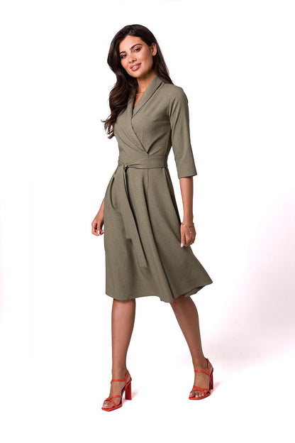 Chic feminine flared daydress in olive green, featuring a shawl collar and waist tie, elegantly styled by BeWear on a model, ideal for a sophisticated look.