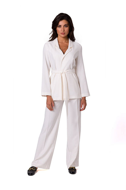 Fashionable model in a tailored white BeWear summer jacket with a chic belt, paired with matching trousers, exuding sophistication and comfort for warm weather.