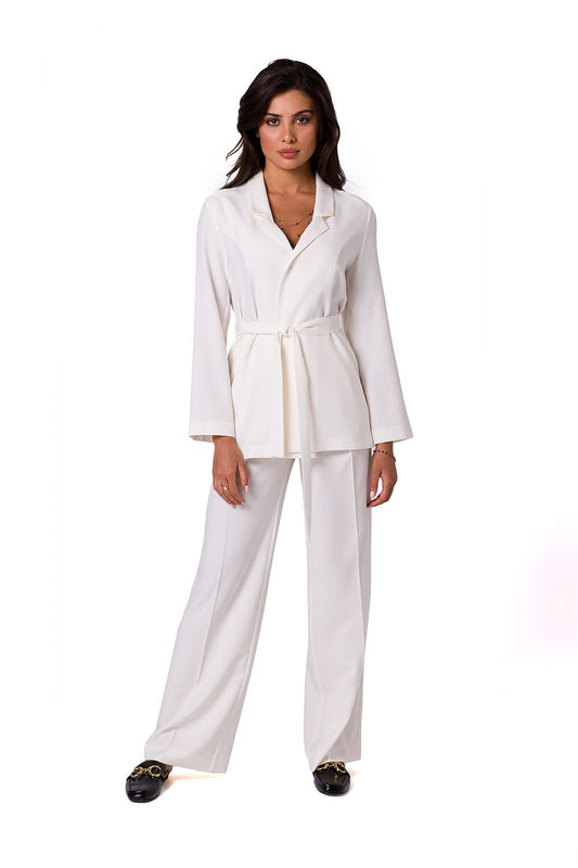 Fashionable model in a tailored white BeWear summer jacket with a chic belt, paired with matching trousers, exuding sophistication and comfort for warm weather.