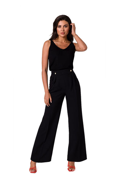 Chic black lightweight trousers by BeWear, adorned with decorative gold buttons, elegantly fitted high waist, model posing confidently with a stylish top and vibrant heels.