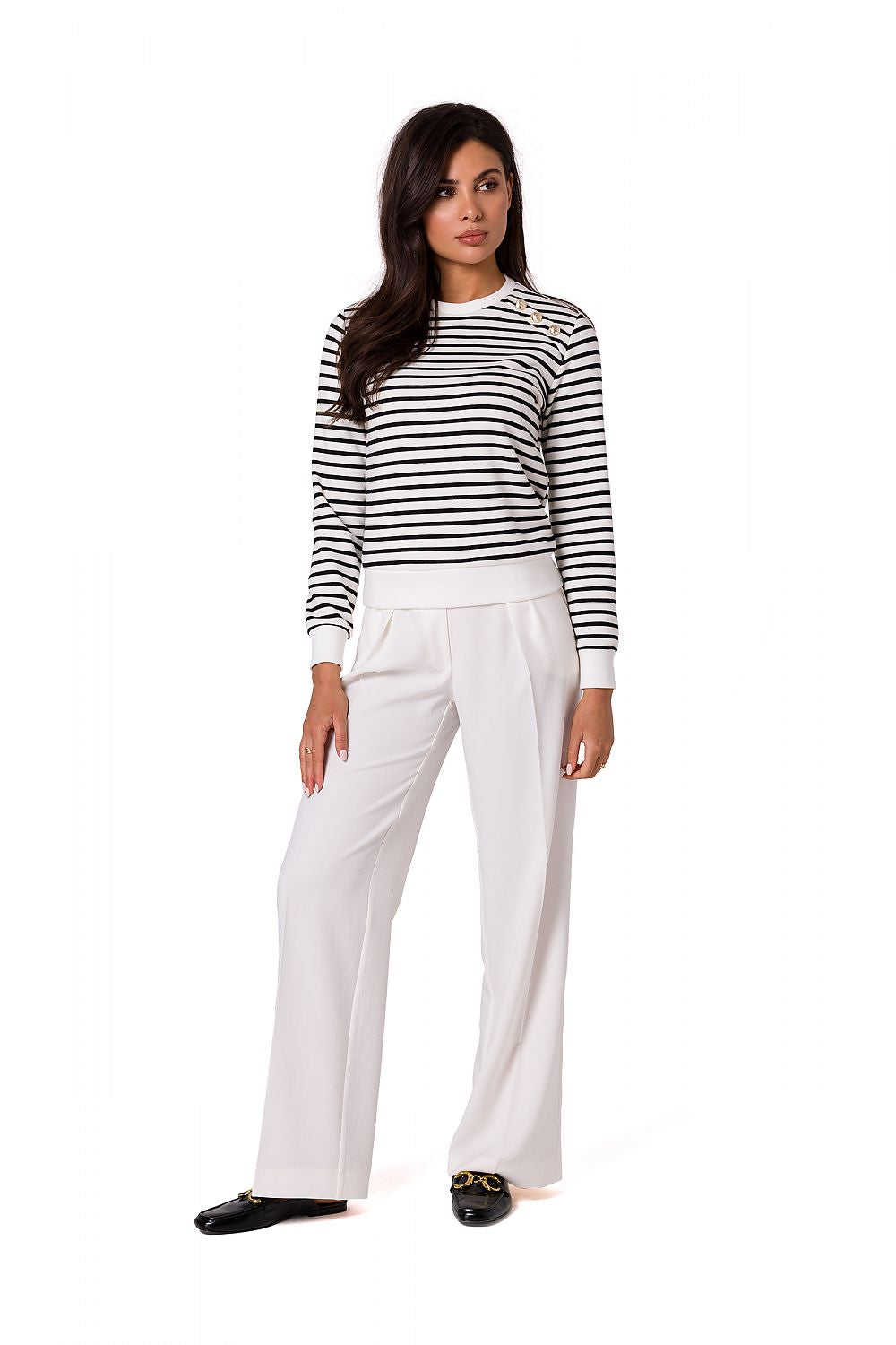 Sophisticated model in a navy striped cotton knit sweatshirt with decorative gold buttons by BeWear, paired with fashionable white wide-legged trousers for a refined look.