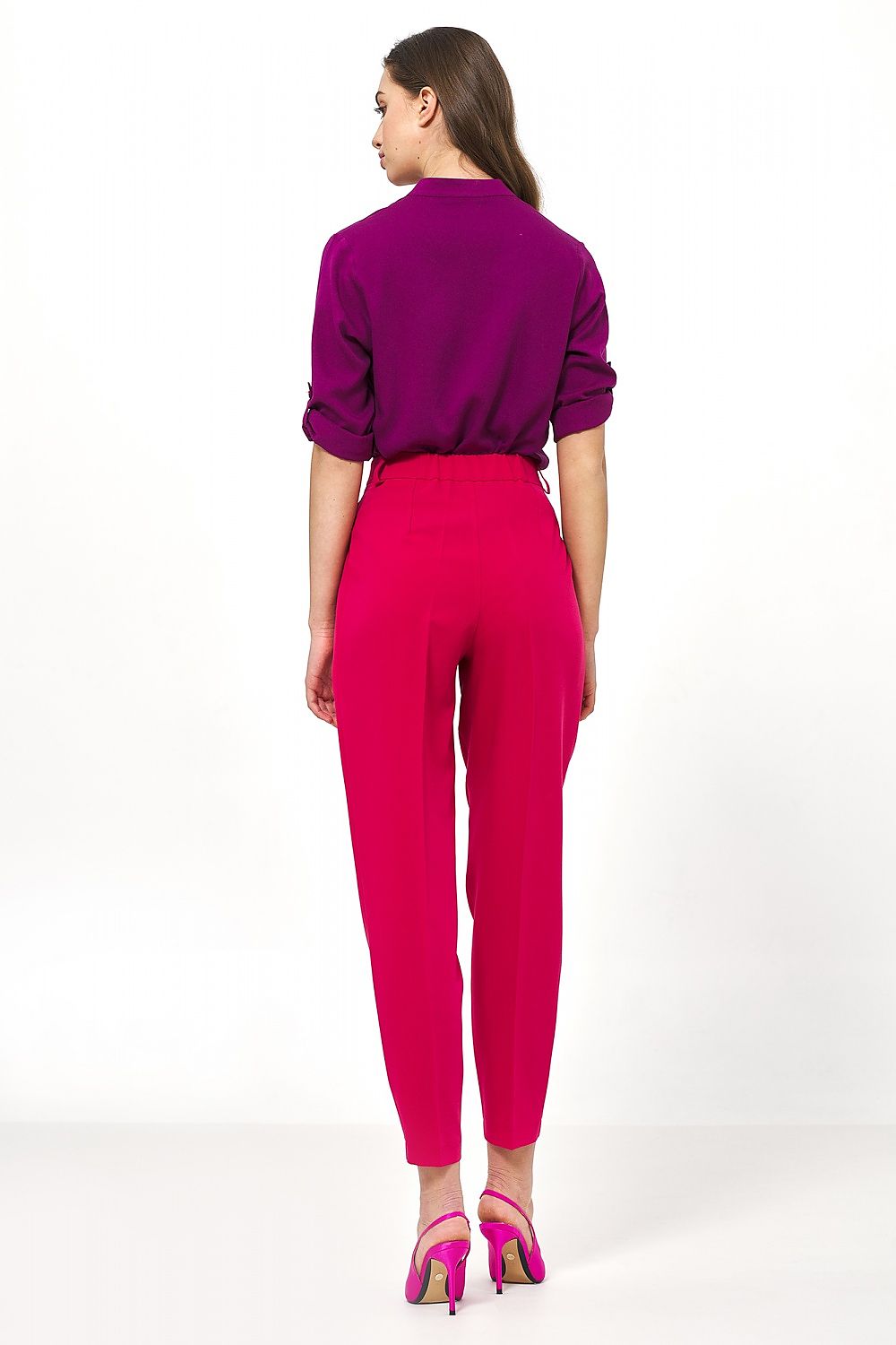 Elegant high-waisted balloon pants in vibrant pink by Nife, styled with a purple blouse, showcasing a trendy office look from the back.