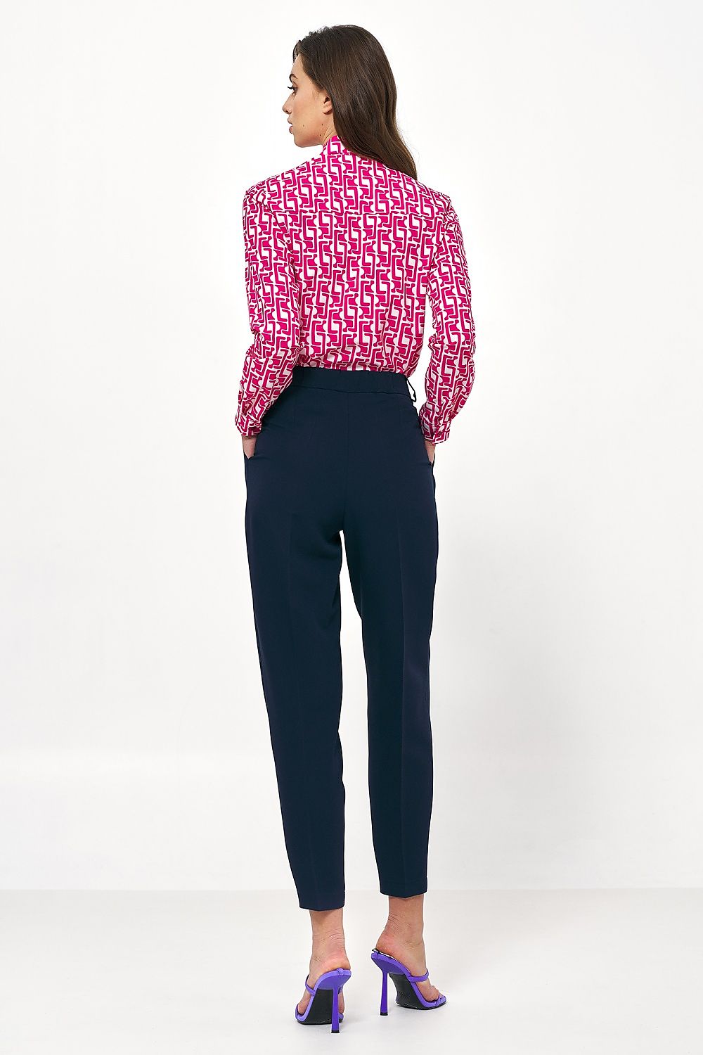 Sleek high-waisted navy balloon pants by Nife, alongside a vibrant patterned blouse, offering a blend of contemporary elegance and sophistication.