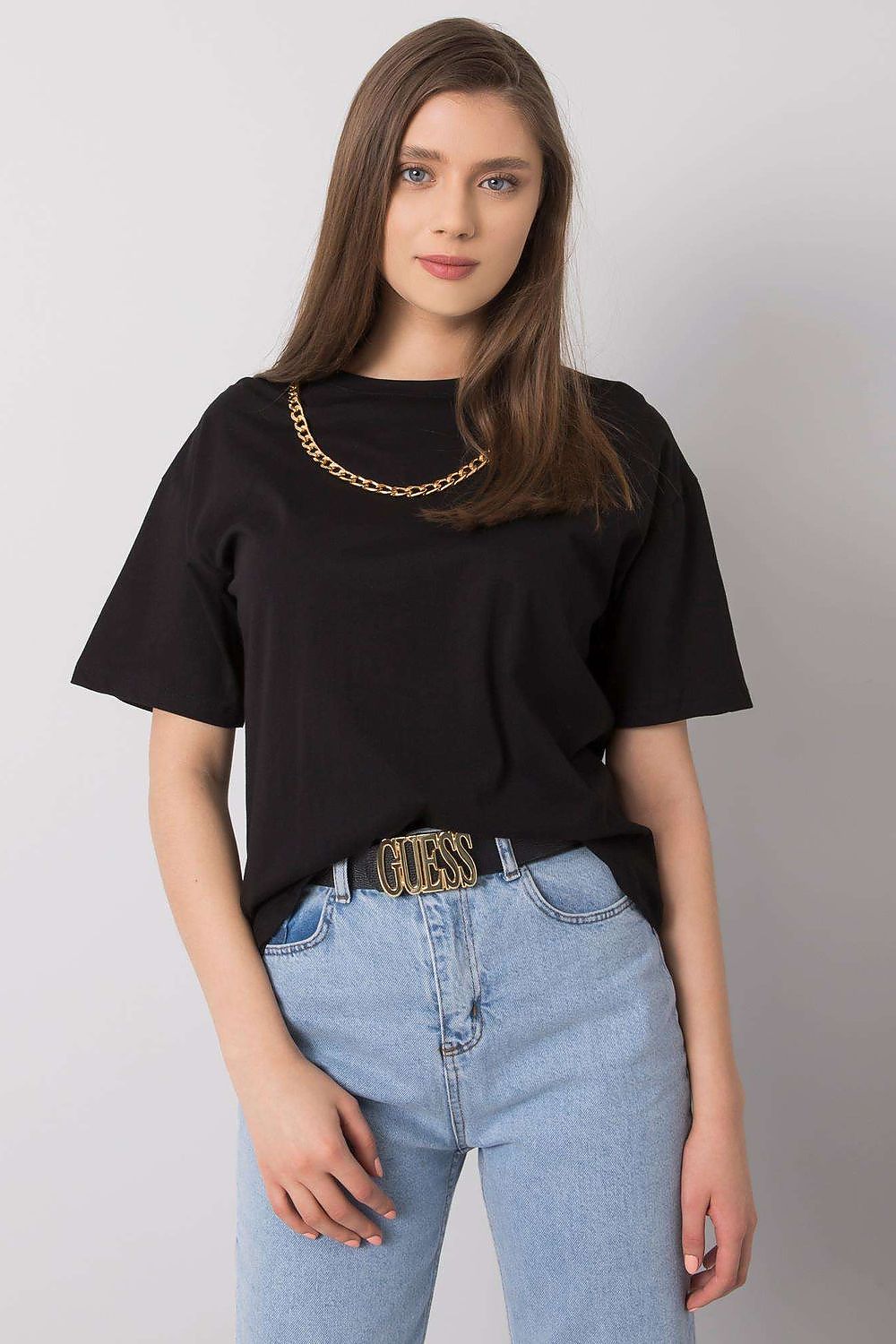 Elegant women's black loose fit t-shirt by Rue Paris adorned with a decorative chain, paired with high-waisted jeans and chic accessories.