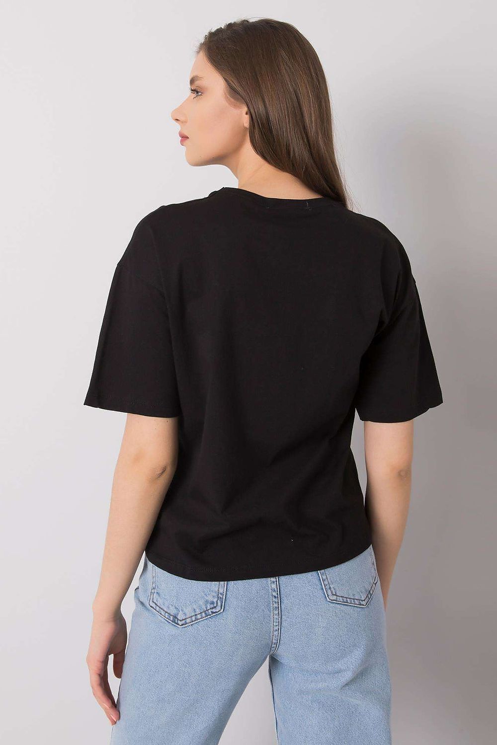 Back view of a radiant model wearing a black loose fit t-shirt by Rue Paris, emphasizing the chic design and relaxed silhouette, paired with denim.