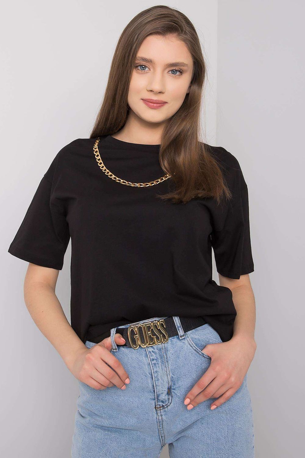 Close-up of a fashionable women's black t-shirt by Rue Paris with decorative chain highlight, perfectly styled with high-waisted jeans and a statement belt.