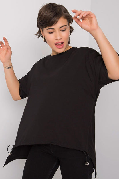 Playful pose of a woman in an elegant cotton t-shirt by Rue Paris, embodying contemporary luxury and comfort.