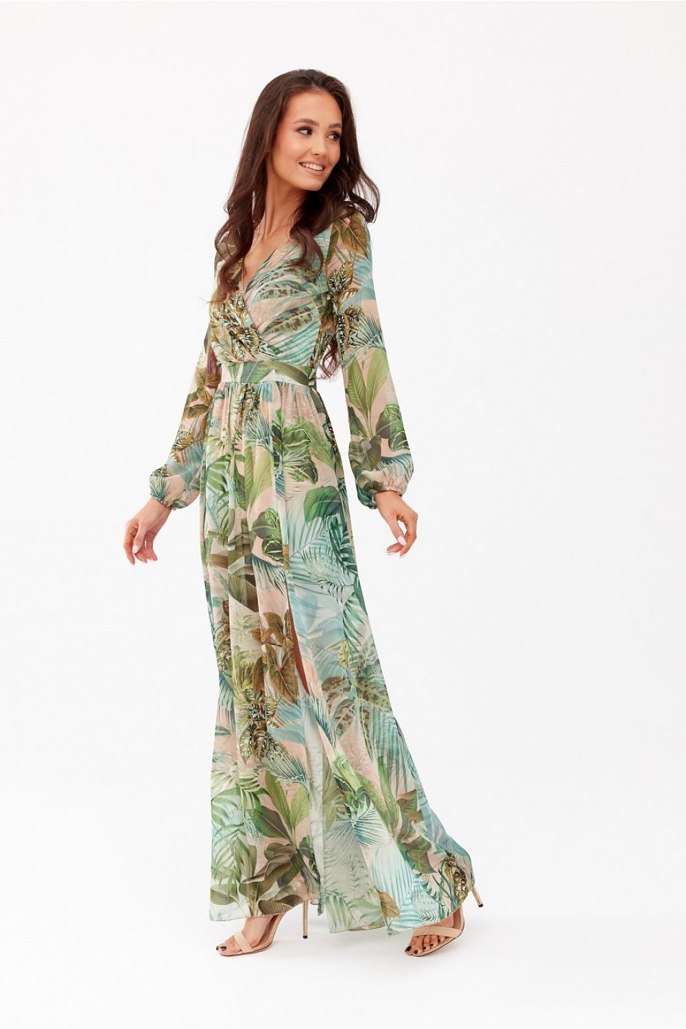 Charming woman in a flowing floral maxi dress by Roco Fashion, designed for sophistication, exuding confidence with a beautiful pattern perfect for elegant occasions.