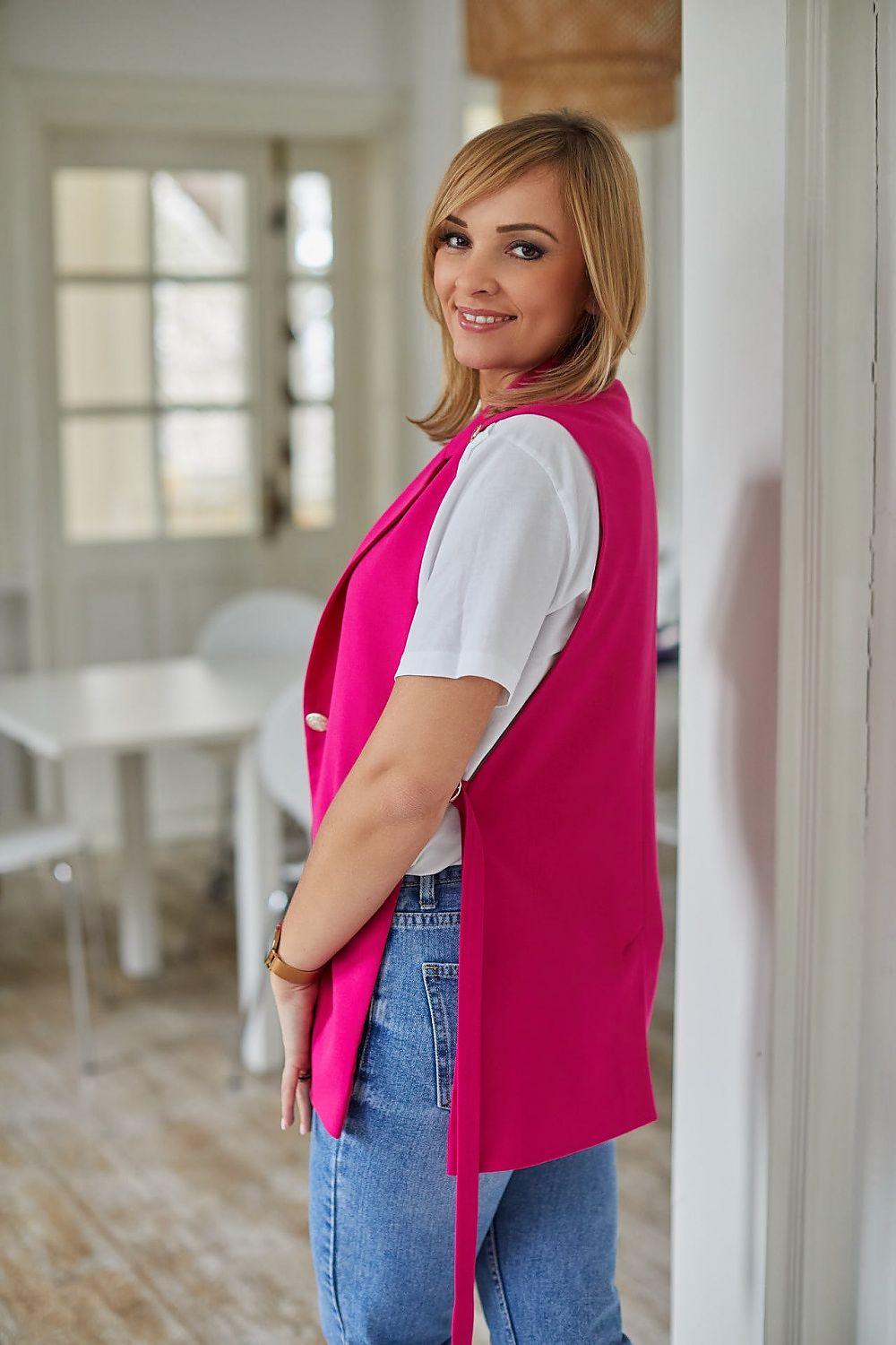 La Aurora designer jacket vest in vibrant pink, styled with a white t-shirt and trendy jeans. Perfectly tailored fit highlighting sleek lines and quality craftsmanship.