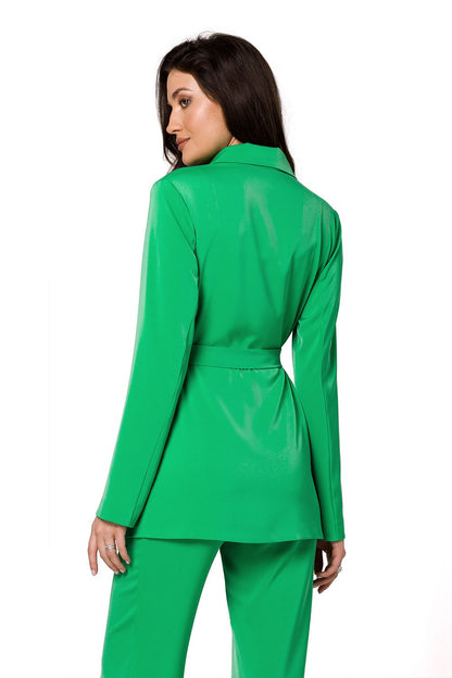 Back view of a luxury women’s flowing jacket in vibrant green by Makover, styled with a matching green outfit, showcasing elegant tailoring and a belted waist.