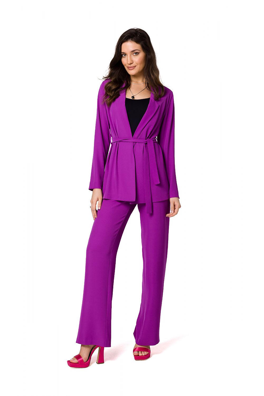 Model showcasing a luxury flowing purple jacket and matching trousers by Makover, accentuated with stylish high heels, exuding a fashionable charm.