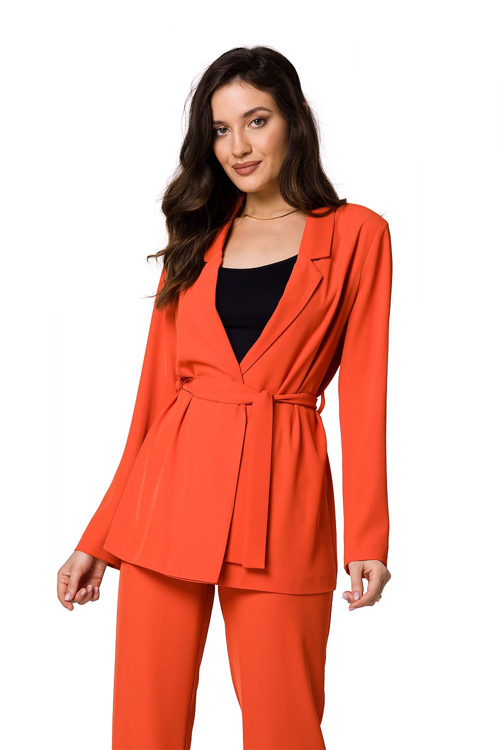 Model in a luxury flowing jacket in vibrant orange by Makover, elegantly styled over a black top, radiating a bold and sophisticated look.