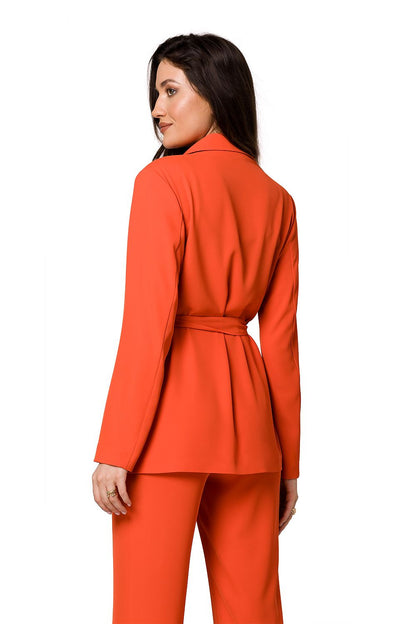 Back view of a luxury women's flowing jacket in vibrant orange, elegantly tied with a belt, designed by Makover.