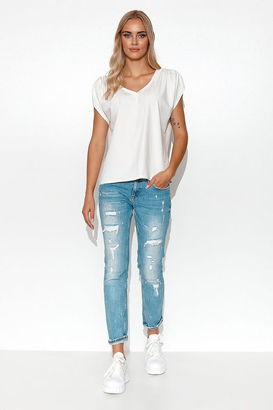 Front view of an elegant Makadamia oversized blouse with deep V-neck, styled with distressed jeans, showcasing versatility for various occasions.