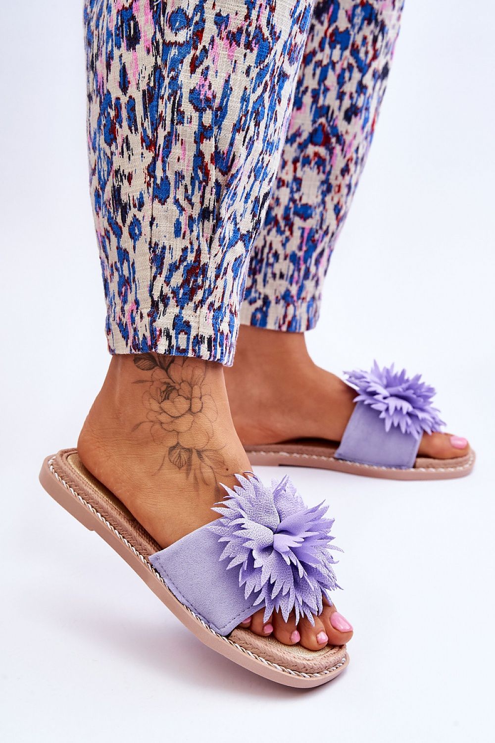Close-up view of sophisticated women's eco-suede flip-flops from Step in Style, showcasing floral embellishments, perfect for chic summer style.