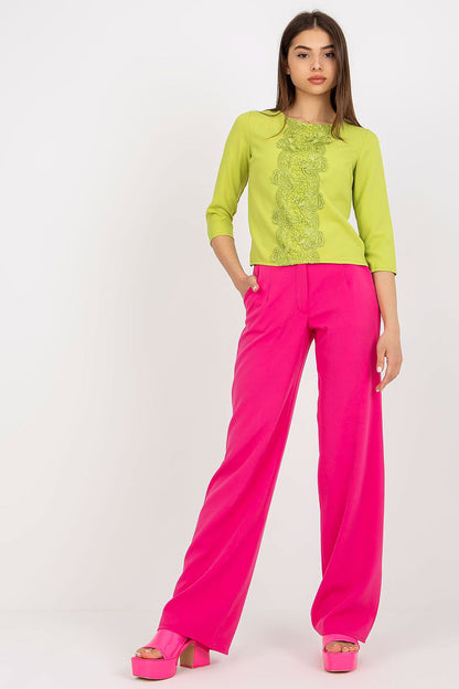 Chic Lakerta blouse with 3/4 sleeves, embellished with delicate lace, worn with bold pink wide-leg trousers for a sophisticated ensemble.