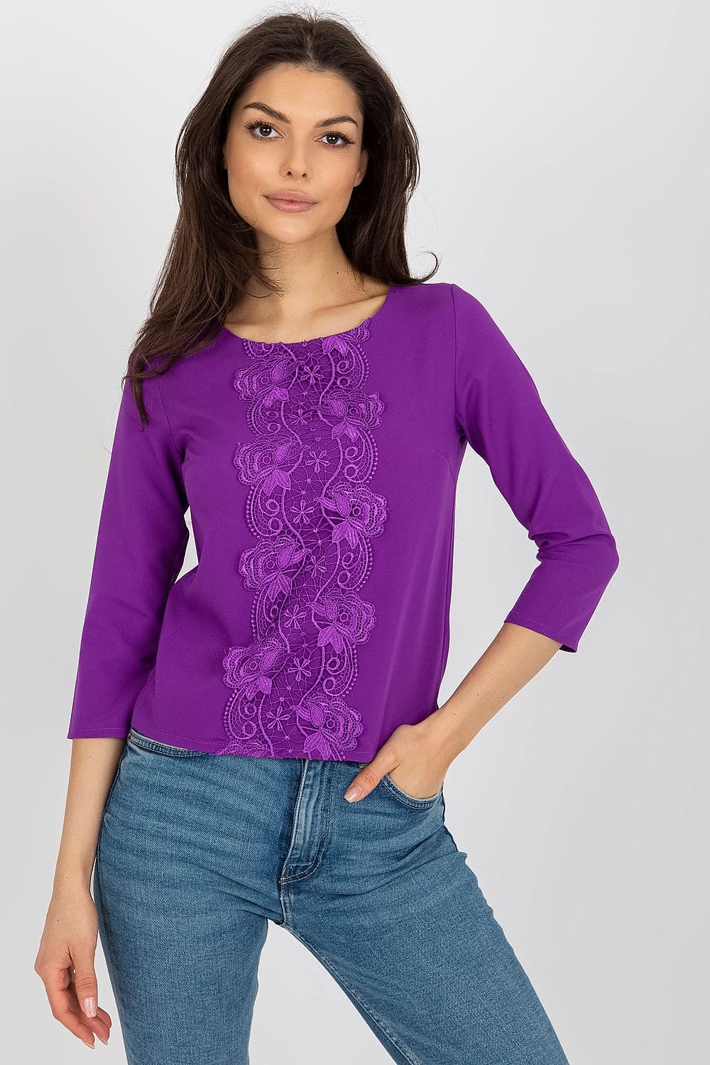 Sophisticated purple Lakerta blouse featuring intricate lace detailing along the centre, complemented by a casual denim look, ideal for fashionable occasions.