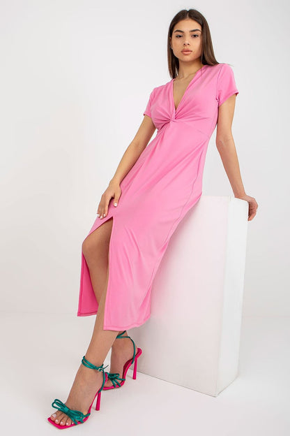 Stylish pose of a model wearing a vibrant pink daydress with a twist detail and side slit, designed by Italy Moda, perfect for summer events.