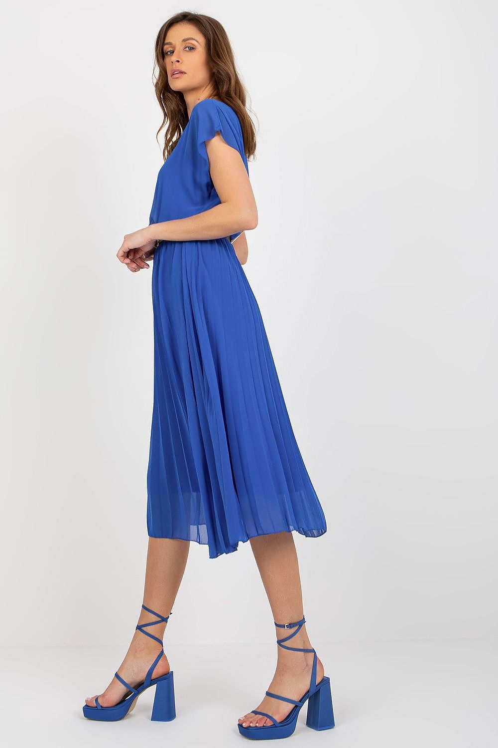 Side view of a luxurious blue cocktail dress by Italy Moda with short sleeves and pleats, styled with elegant high-heeled sandals, ideal for formal occasions.