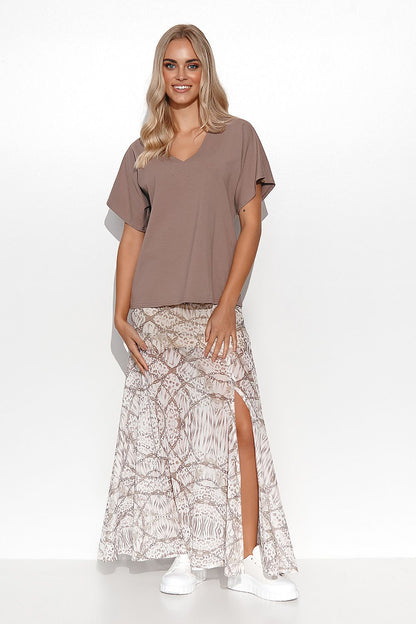 Trendy look of a woman in a brown blouse from Makadamia, paired with a flowing patterned skirt, perfect for a modern and elegant spring-summer outfit.