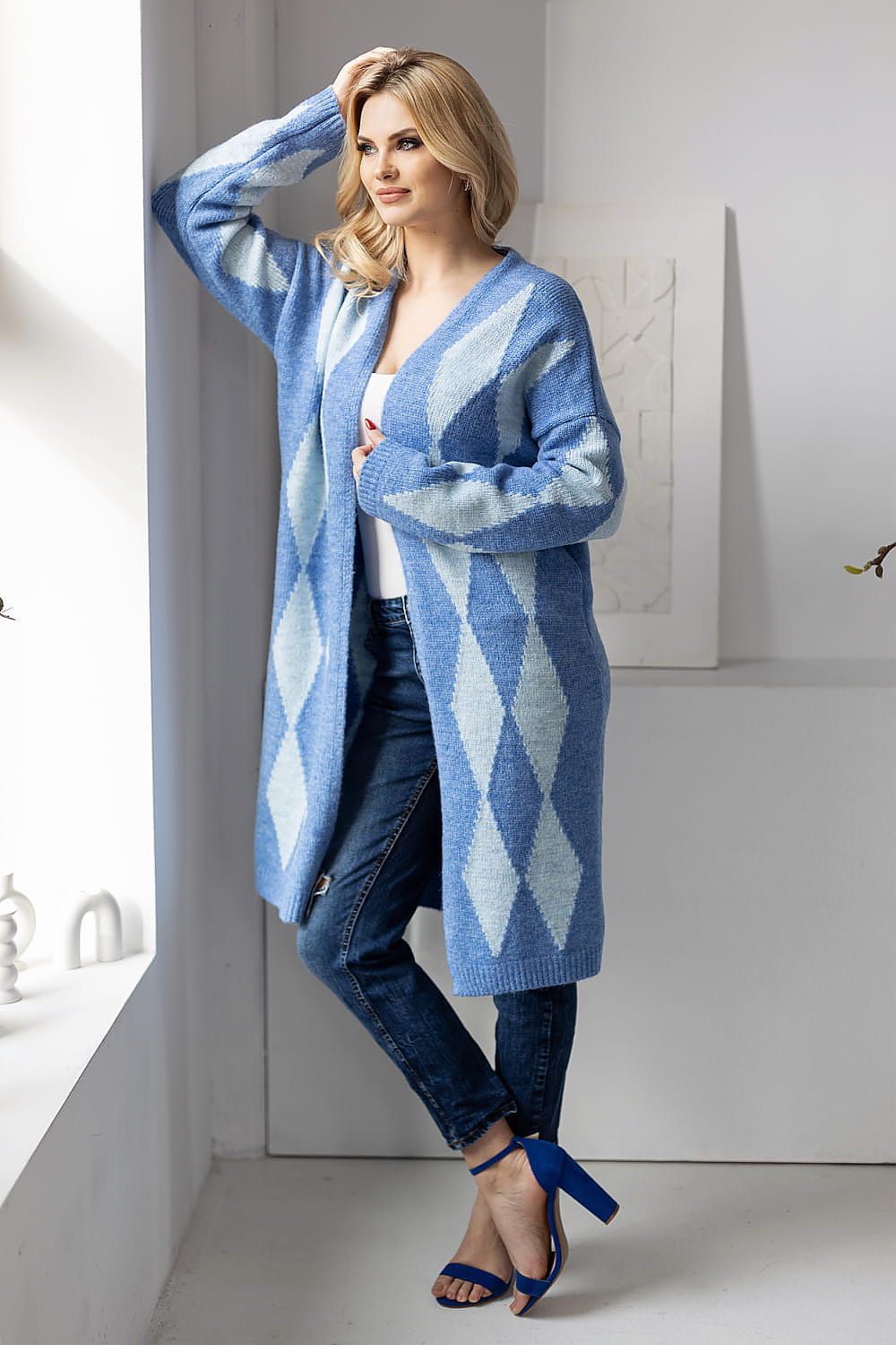 Luxurious long sleeve blue geometric pattern cardigan by PeeKaBoo, styled with chic denim jeans and high heels, perfect for layering.