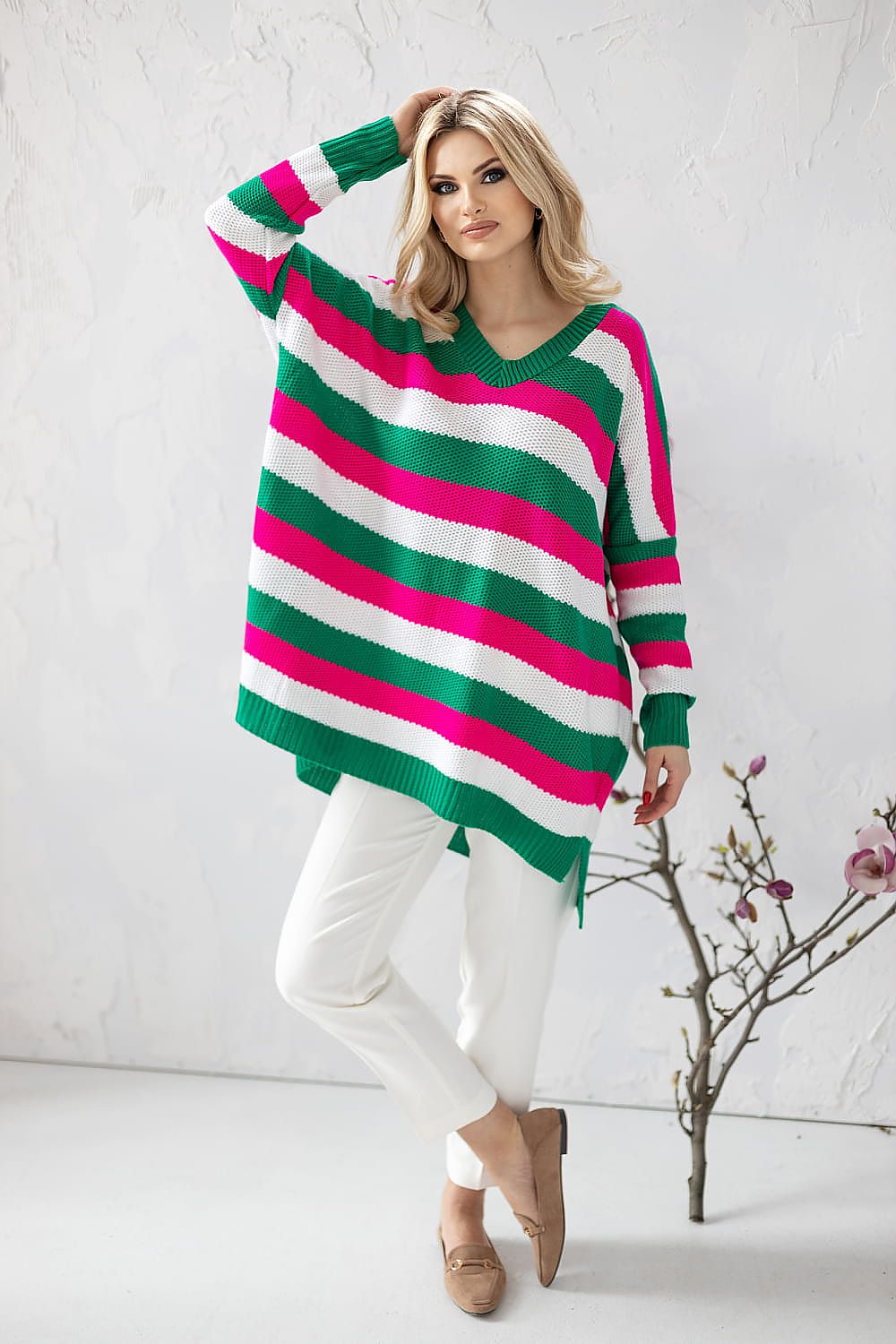 Elegant loose-fitting acrylic sweater with colourful stripes and heart neckline, styled with white trousers, by PeeKaBoo.