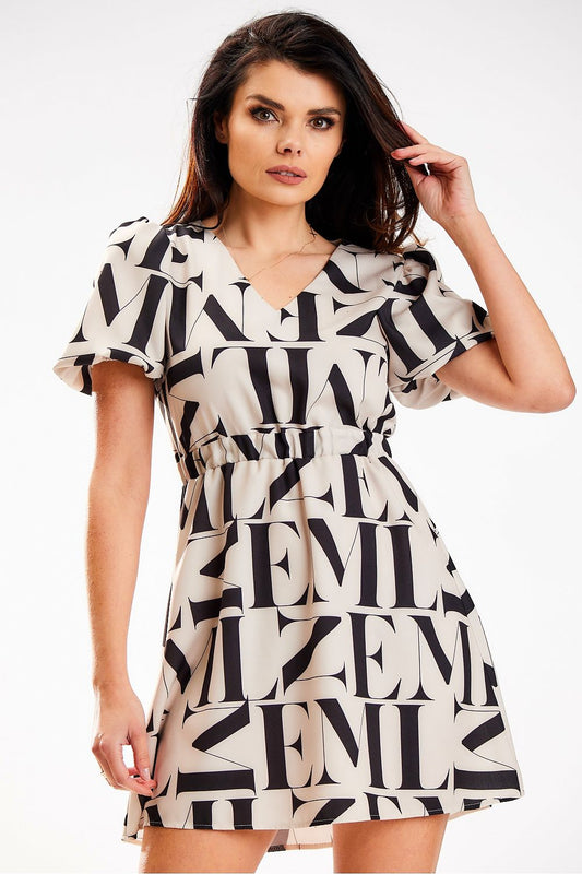Elegant model showcasing a luxe beige crepe mini dress featuring a heart-shaped neckline and elastic waistband by Awama, accented with bold black lettering, perfect for fashionable summer outings.