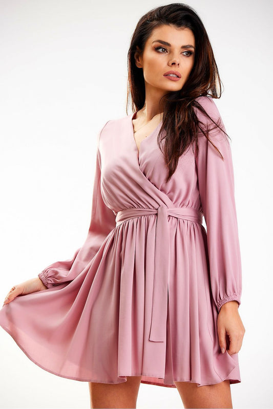 Elegant mini length dress with long sleeves and a belt by Awama, showcased on a model. The dress features a soft pink hue, perfect for special occasions or casual outings.