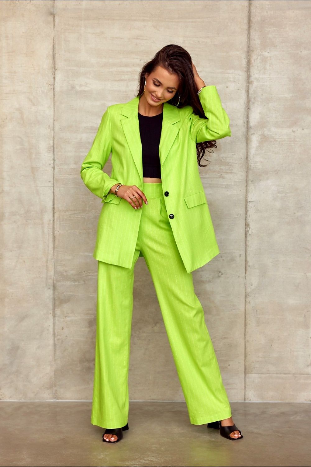 Fashion model elegantly paired in Roco Fashion's matching lime green blazer and high-rise wide cut trousers, presenting a chic and sophisticated look.