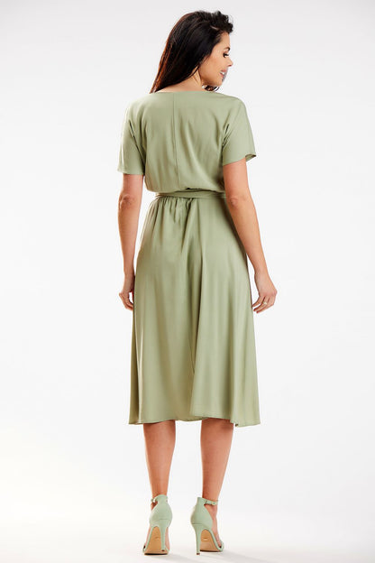 Back view of the luxurious midi length kimono dress by Awama in soft green viscose, highlighting the elegant sash and airy design.