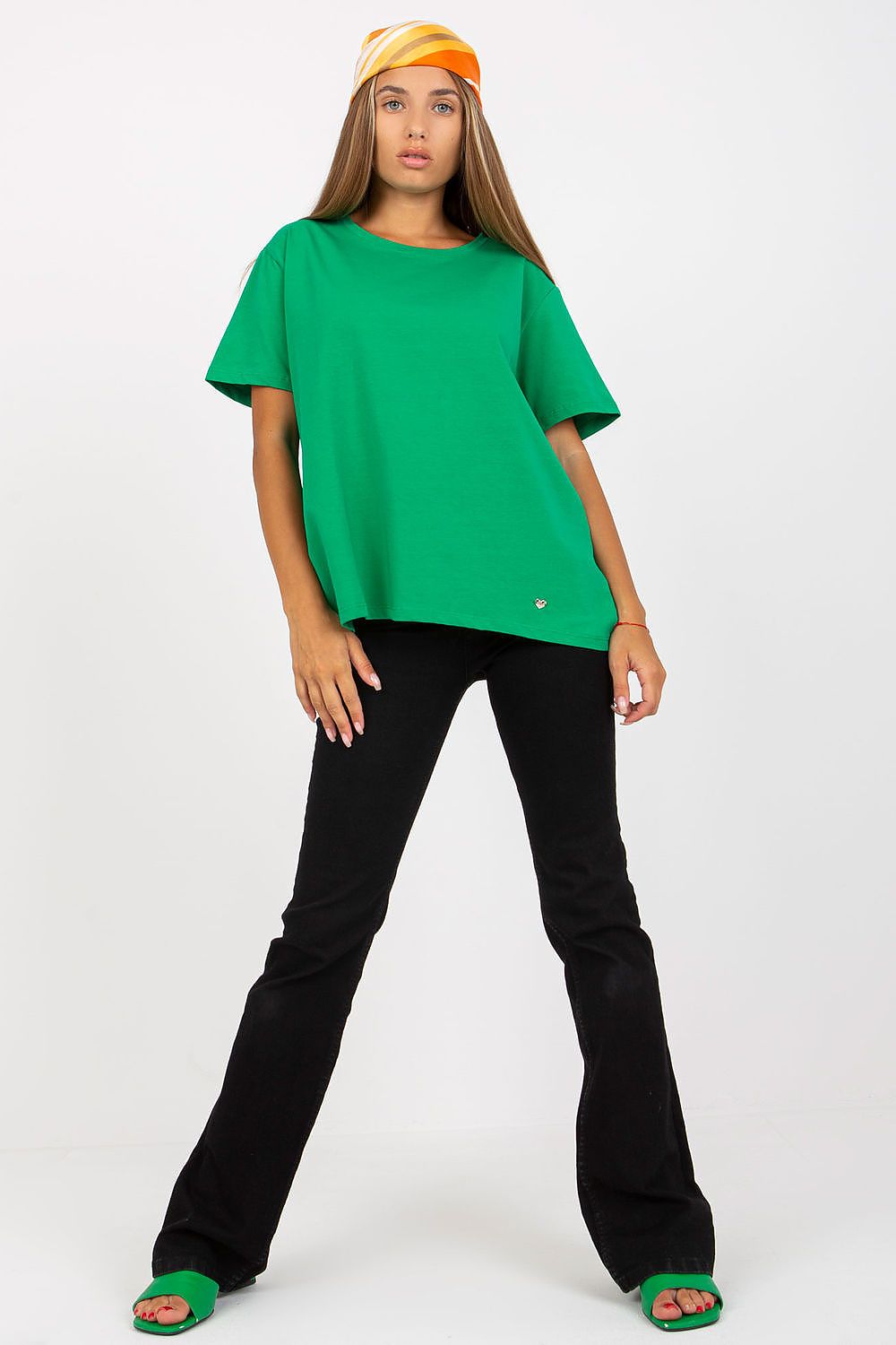 Luxury Women's BFG T-Shirt in striking green, featuring short sleeves and a round neckline, elegantly styled with black flared trousers, showcasing a modern fashion statement.