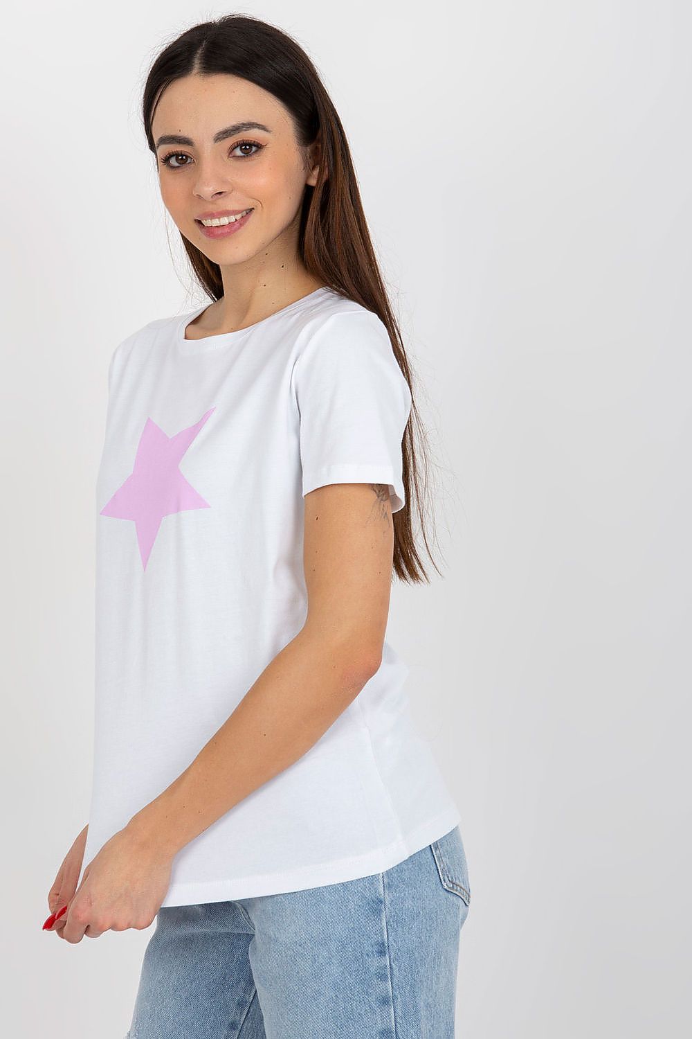 Elegant woman showcasing a luxury women's cotton spandex BFG T-shirt, featuring a decorative pink star print on a white background, styled with casual denim jeans for a chic look.