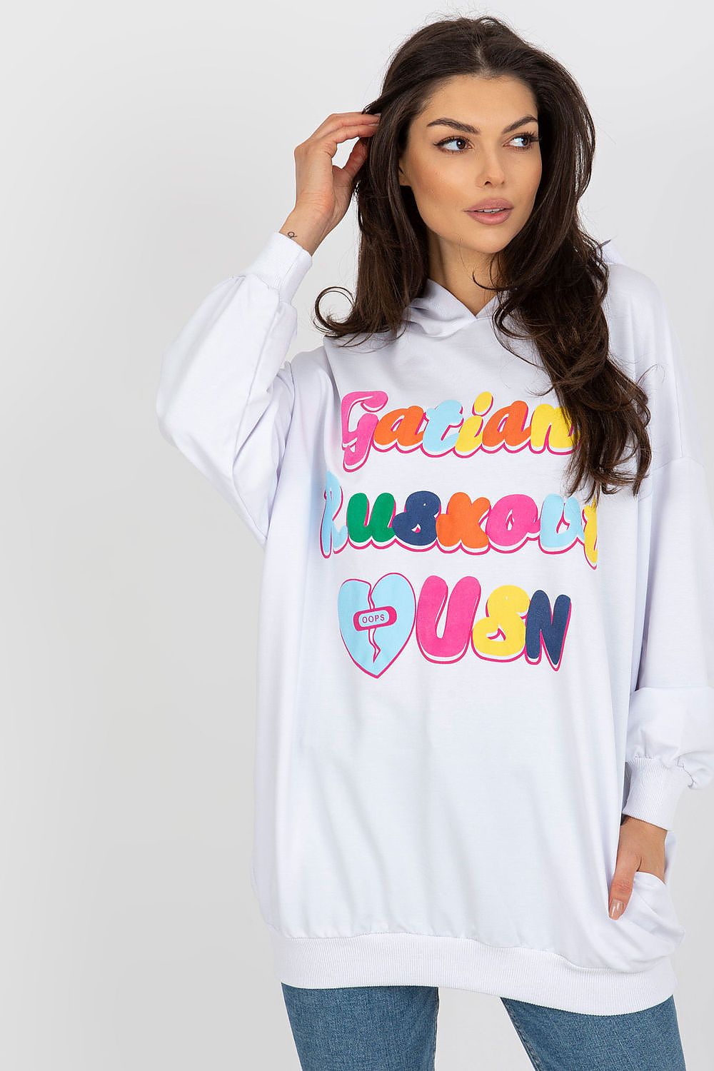 Luxurious white women's hooded sweatshirt with long sleeves and decorative colourful front inscription by Fancy, styled casually with a modern hairstyle.