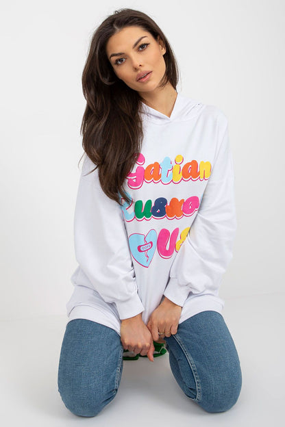 Elegant women's hooded sweatshirt in white featuring vibrant decorative text, designed by Fancy, showcased in a relaxed seated pose.