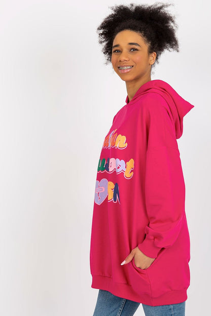 Chic women's pink hooded sweatshirt showcasing vibrant decorative lettering, crafted by Fancy for a trendy look.