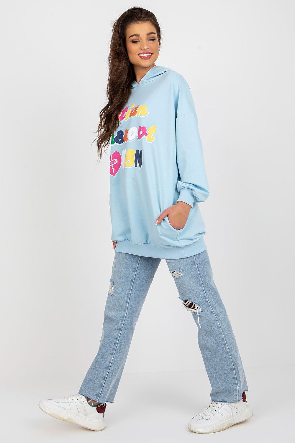 Stylish women's hooded sweatshirt by Fancy in blue, model standing with a playful pose, featuring a vibrant decorative inscription.