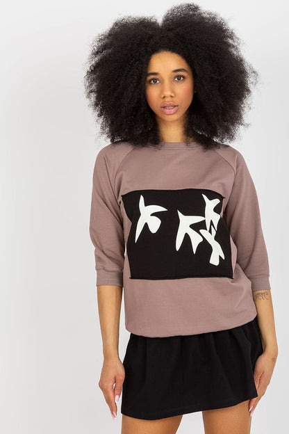Elegant 2-piece sweatshirt set by Fancy featuring a round neckline, three-quarter sleeves, and decorative print, complemented by a stylish black skirt.