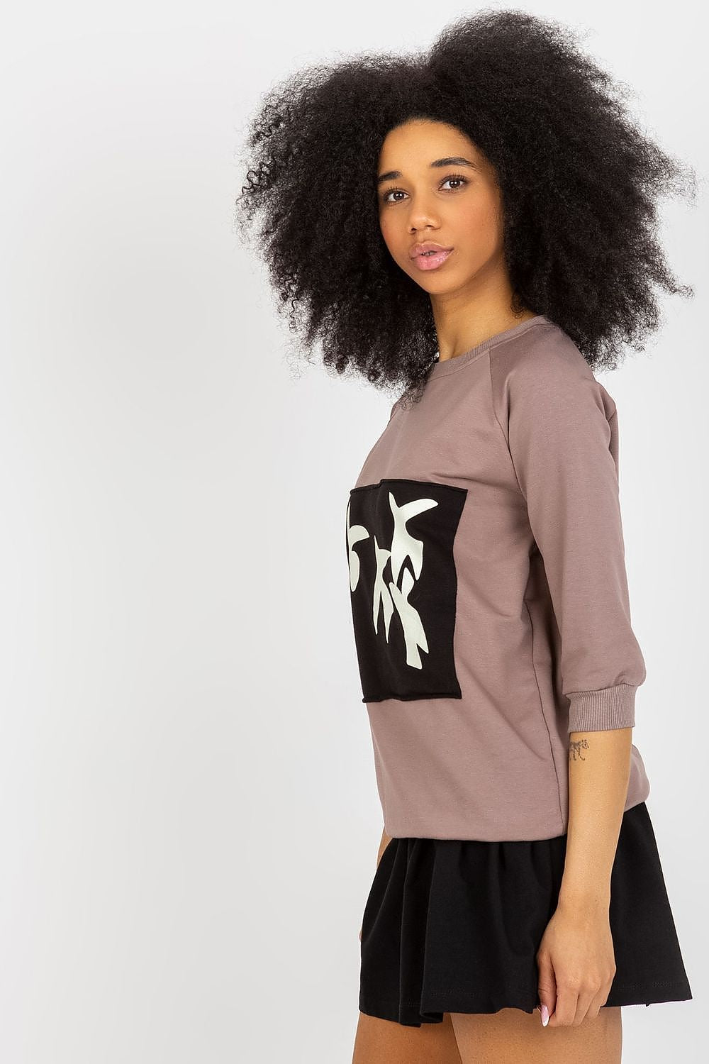 Sophisticated view of a Fancy sweatshirt set with a round neckline and decorative print, paired beautifully with a flared black skirt.