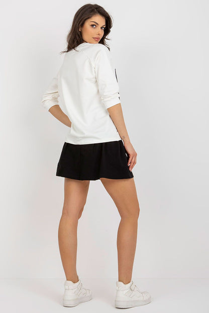 Sophisticated view of the back of a 2-piece sweatshirt set by Fancy, showcasing a white blouse and flattering black skirt, worn by a model.