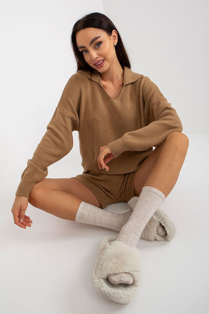 Luxurious casual 2-piece set by EM featuring a looser cut sweater and short shorts, styled with cosy oversized slippers and ribbed socks, ideal for relaxed afternoons.