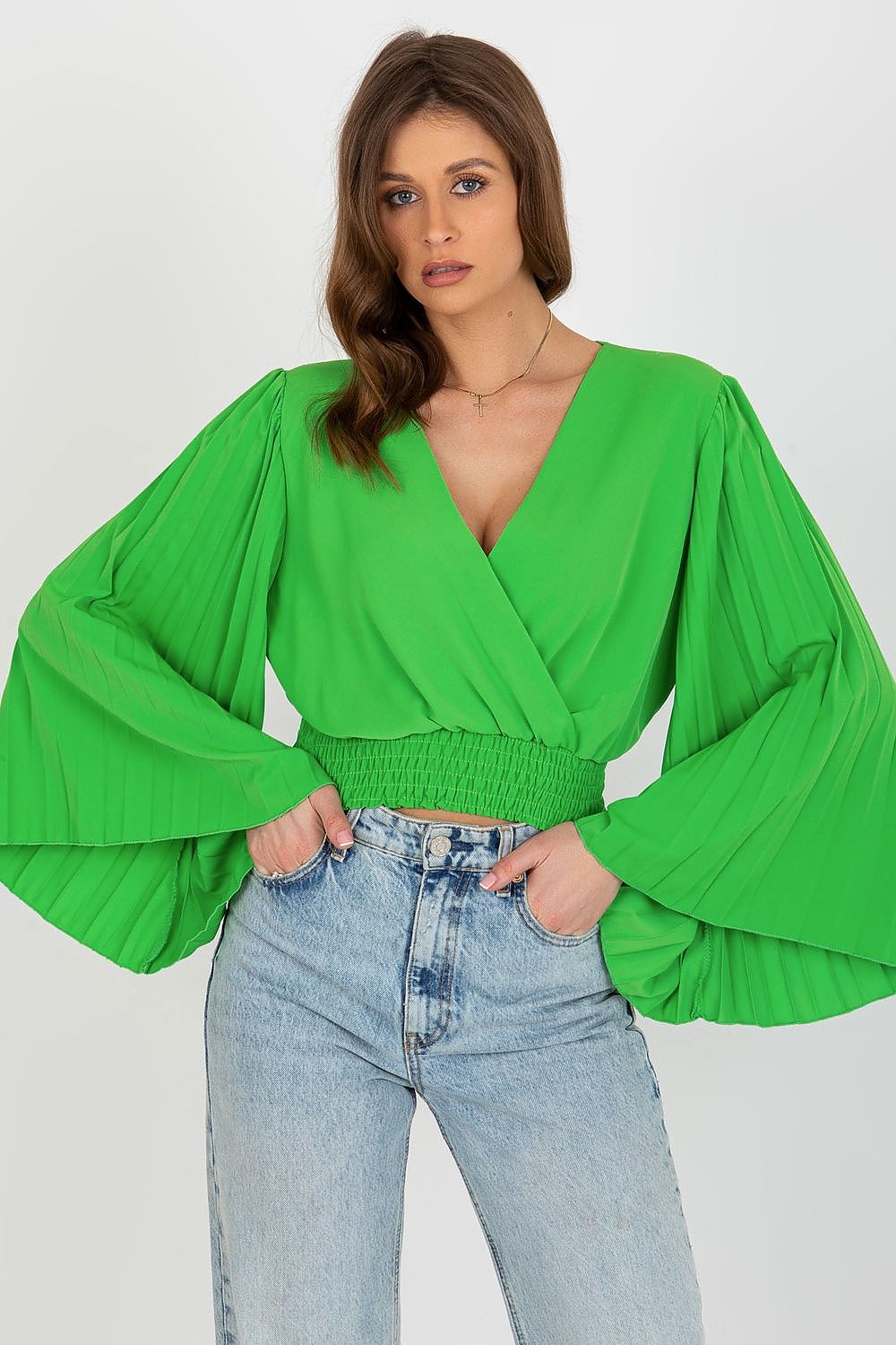 Luxurious green blouse by Italy Moda featuring pleated long sleeves and an elegant envelope neckline, styled with classic denim for a chic look.