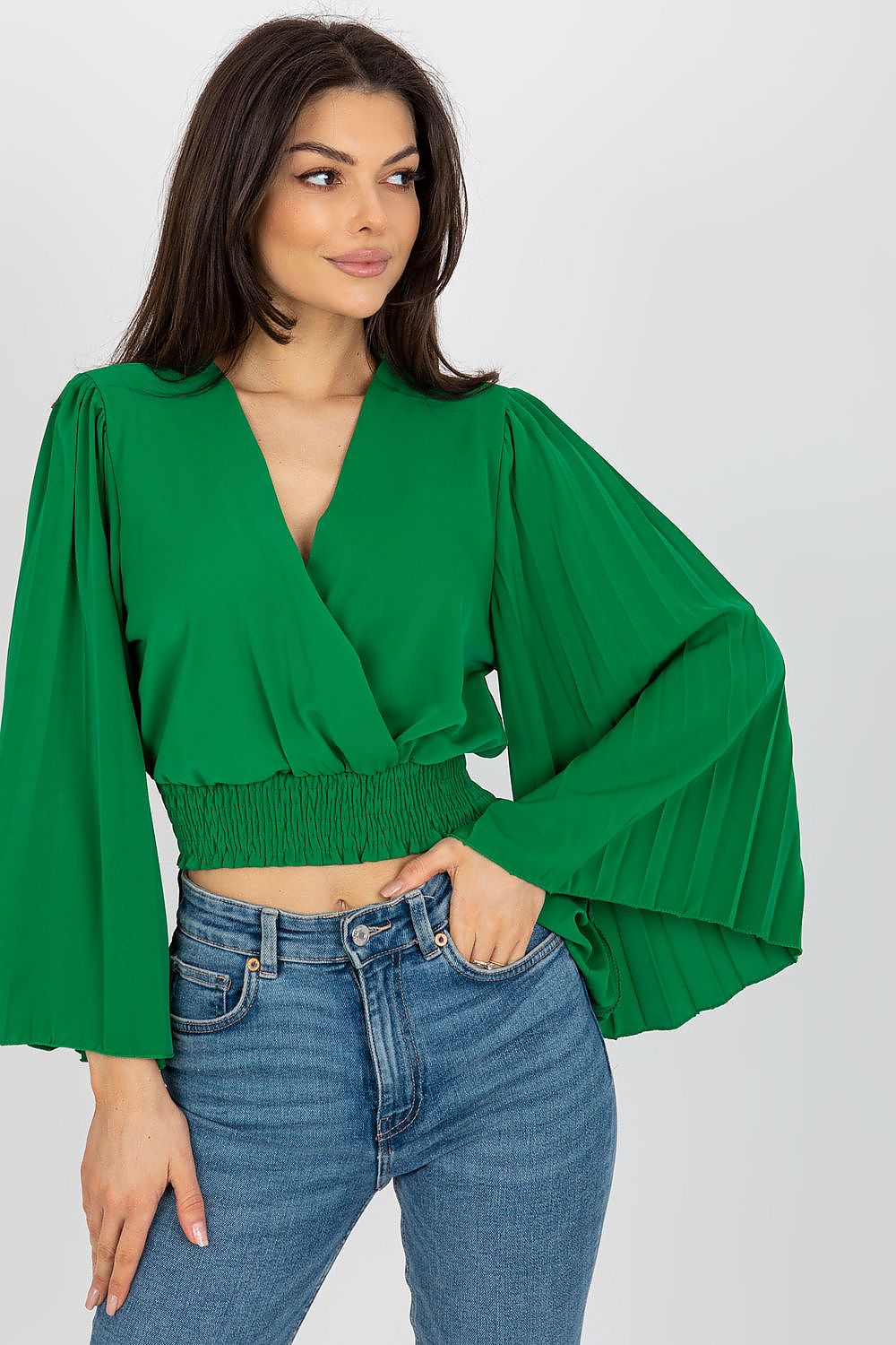 Luxurious green Italy Moda blouse with pleated long sleeves and a flattering envelope neckline, paired with high-waisted jeans.