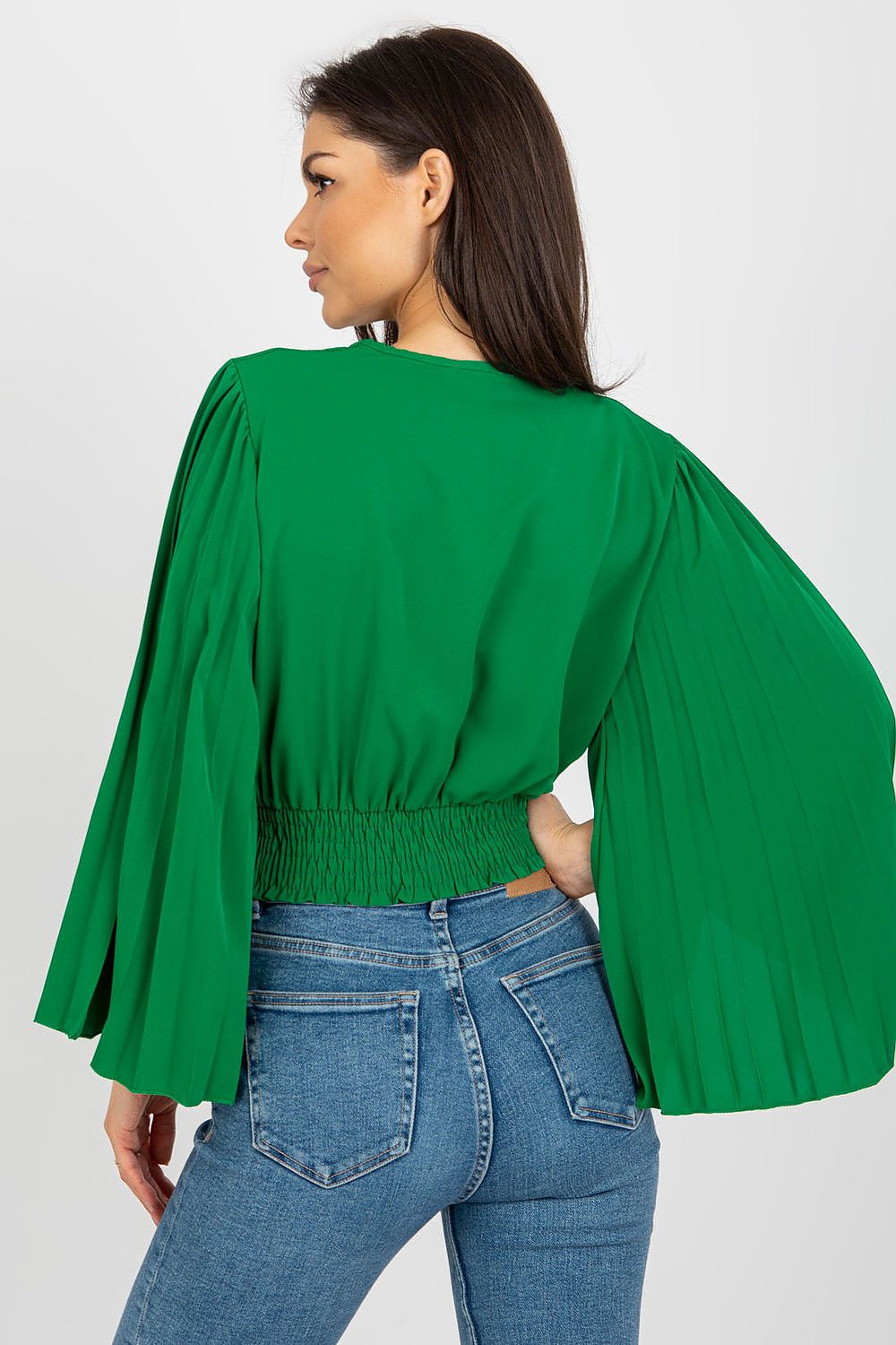 Chic back view of a green Italy Moda blouse showcasing pleated sleeves and a smocked waist, styled with fitted jeans.
